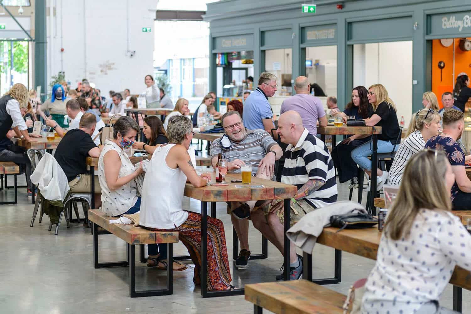 People enjoying drinks outside food stalls